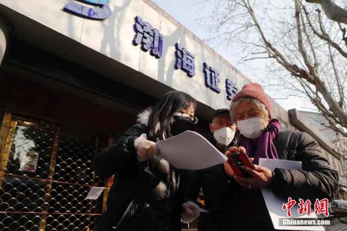 2020年2月3日,在渤海证券上海彰武路营业部门前,工作人员指导股民网上交易流程。中新社记者 殷立勤 摄 创业板改革!涨跌幅限制拟提高至20%,炒股将更刺激